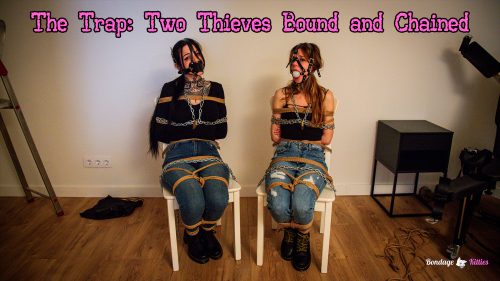 Aly and Dolly Darko hogtied to chairs with rope bondage, harness gags and chains locked with padlocks.